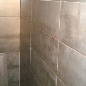 Flislegging på vegg med grå fliser.