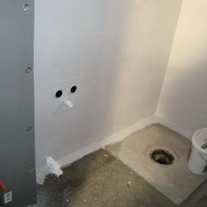 Dusjhjørne med sluk i gulvet før flislegging. Ferdigstøpt gulv.